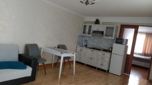 a small kitchen with a small table and a white refrigerator at Anas apartments in Zugdidi +2 photos