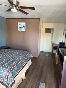 a bedroom with a bed and a ceiling fan at Cinderella Motel in Wasco