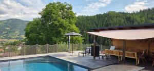 a swimming pool with a table and an umbrella at Landhaus Pool and Relax in Bruck an der Mur