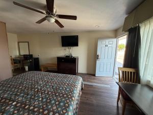 a bedroom with a bed and a ceiling fan at Cinderella Motel in Wasco