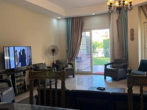 a living room with a couch and a tv and a sliding glass door at North Coast sedra resort Villa, قرية سيدرا الساحل الشمالي in Alexandria