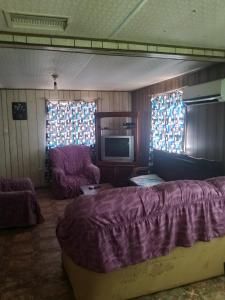 a living room with a bed and a tv at Mobil-home in Rebaïb
