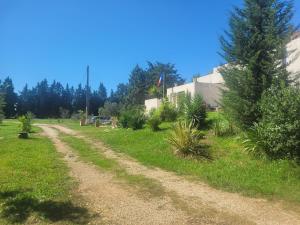 a dirt road in a field with trees and a house at Villa Blanche - Teritoria in Arles