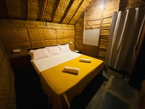 a small room with a bed with two towels on it at Sunshine café Hampi in Hampi