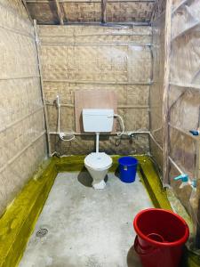 a bathroom with a toilet and a bucket at Sunshine café Hampi in Hampi