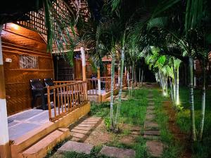 a row of palm trees in front of a house at Sunshine café Hampi in Hampi +3 photos