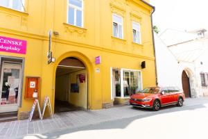 a yellow building with a car parked in front of it at Luxapartment Jacuzzi with Breakfast option in Košice