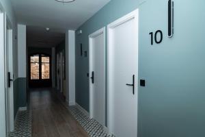 a hallway with blue walls and white doors at El Convento in Molina de Aragón +12 photos