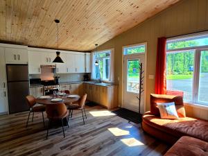 a kitchen and living room with a table and a couch at Camping Abenaki Aventure - Les Chalets in Pierreville
