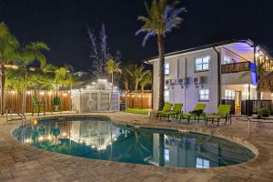 a swimming pool in front of a house at night at Coconut Grove Resort in Clearwater Beach