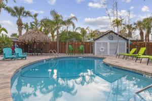 a swimming pool with chairs and a house at Coconut Grove Resort in Clearwater Beach +73 photos