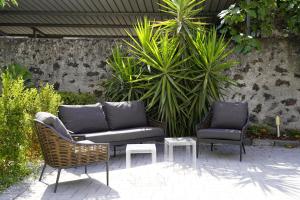 zwei Stühle und ein Sofa auf einer Terrasse in der Unterkunft Hotel Pietranera in Catania