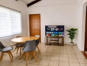 a dining room with a table and a tv at La Casita de Yan in Puerto Viejo