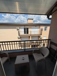 a balcony with chairs and a table and a building at Andrejić 1 in Veliko Gradište