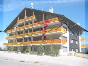a large building with yellow and orange balconies on it at Immeuble Panorama in Les Collons