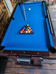 a blue pool table with a cue and balls at Magiczna Chatka Nad Rzeką Bieszczady in Wietrzno