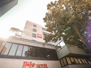 a big building with a big tree in front of it at ibis Porto Centro São Bento in Porto