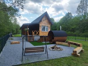 a small cabin with a bench in front of it at Magiczna Chatka Nad Rzeką Bieszczady in Wietrzno
