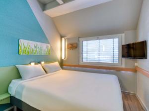 a bedroom with a large bed and a window at ibis budget Hotel Luzern City in Lucerne