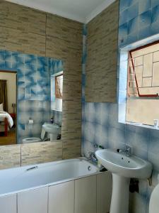 a bathroom with a tub and a sink and a mirror at Lapaleholo Guesthouse in Phuthaditjhaba +76 photos