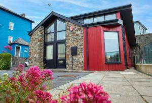 a house with a red door and windows at Ger Y Llanw Aberaeron in Aberaeron