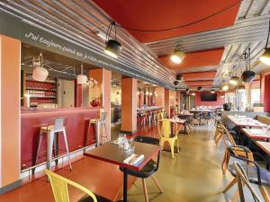 a restaurant with tables and chairs and a bar at ibis Styles Lyon Centre Confluence in Lyon