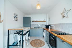 a kitchen with blue cabinets and a counter top at The Graigfryn Hideaway in Amlwch