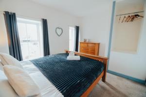 a bedroom with a bed and a window and a dresser at The Graigfryn Hideaway in Amlwch