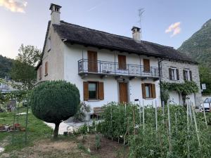 an old white house with a balcony on it at Ca' Mariuccia in Crodo