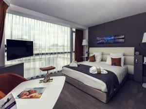 a hotel room with a large bed and a television at Mercure Cherbourg Centre Port in Cherbourg en Cotentin