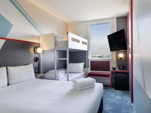a hotel room with a bed and a tv at ibis Budget Auckland Airport in Auckland