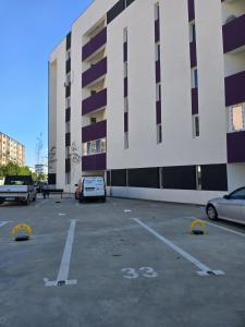 a parking lot with cars parked in front of a building at SECRET JACUZZl & LOVE in Bucharest