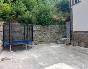 a blue chair sitting in front of a stone wall at Къща Владислав in Radevtsi