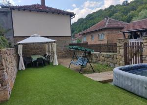 a backyard with a ping pong table and a white screen at Къща Владислав in Radevtsi