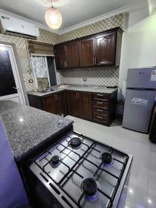 eine Küche mit Herd Backofen oben neben einer Arbeitsplatte in der Unterkunft Remas23 in Irbid