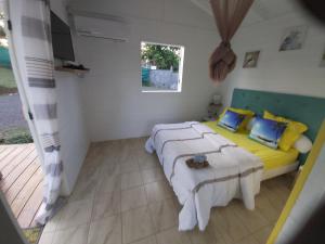a bedroom with two beds and a window at Bungalow chic à Sainte-Rose + piscine. in Sainte-Rose