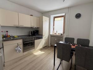 a small kitchen with a table and a table and chairs at Ferienwohnung Stiegel in Ingelheim am Rhein