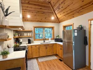 a kitchen with a stainless steel refrigerator and wooden cabinets at Honey Ridge Forest Retreat in South Bloomingville