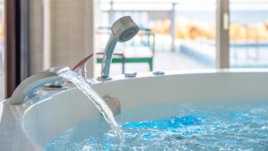 a bath tub with water pouring from a faucet at yeongdeok chaeumneul poolvilla in Yŏngdŏk
