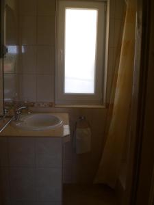 baño con lavabo y ventana en Böne Vendégház és Borozó, en Tokaj