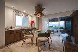 a kitchen and dining room with a table and chairs at Hotel Casa Bahía Cozumel - Adults Only in Cozumel