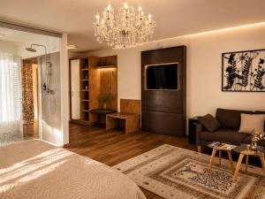 a living room with a bed and a chandelier at KOASA HOF Bed and Breakfast in Oberhaag