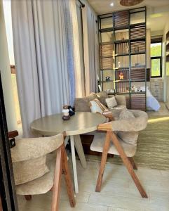 a living room with a table and two chairs at Henderson Homes Uganda in Sisa