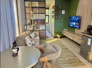 a living room with a table and a tv at Henderson Homes Uganda in Sisa