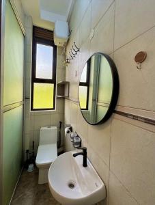 a bathroom with a sink and a mirror and a toilet at Henderson Homes Uganda in Sisa