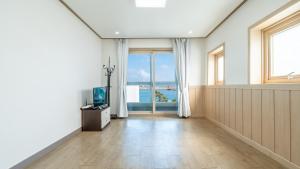 a living room with a television and a large window at Samcheok jangho sanho Pension in Samcheok +7 photos