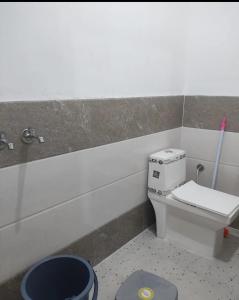 a bathroom with a toilet and a trash can at Hotel Hidden Gem in Pānīpat