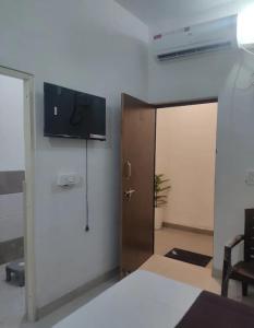 a room with a door with a television on the wall at Hotel Hidden Gem in Pānīpat