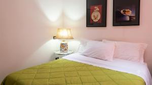 a bedroom with a green and white bed with a lamp at Gaia B&B in Castrovillari