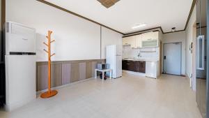 a large room with a kitchen with a tree in it at Geoje Youngsu Pension in Geoje